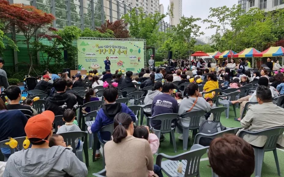 아파트 단지 야외 무대 앞에 의자를 놓고 모인 어린이날 축제 참가자들