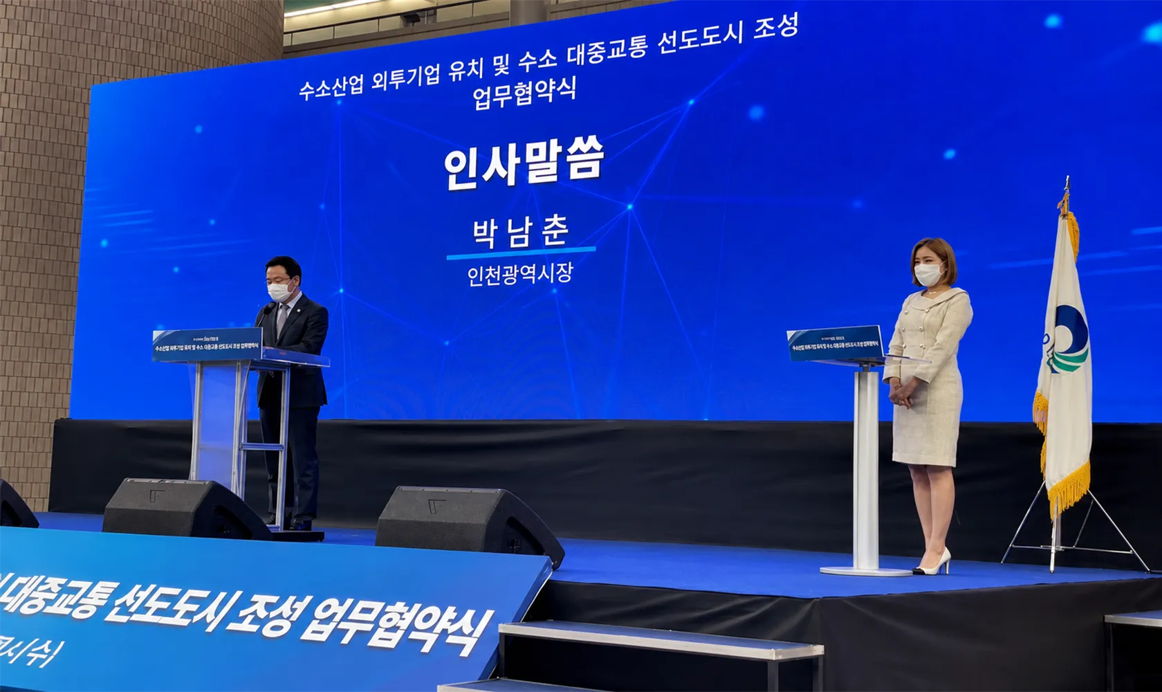 협약식 무대의 대형 LED 백월과 좌우로 나뉘어 놓인 포디움