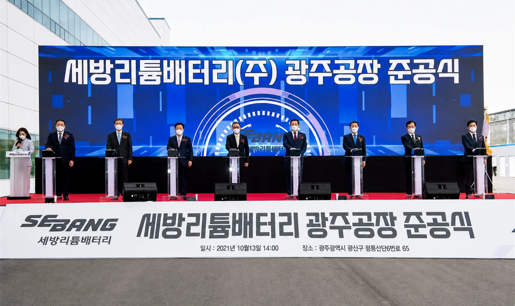 공장 앞 준공식 무대에 세운 대형 LED 백월과 나란히 놓인 투명 포디움