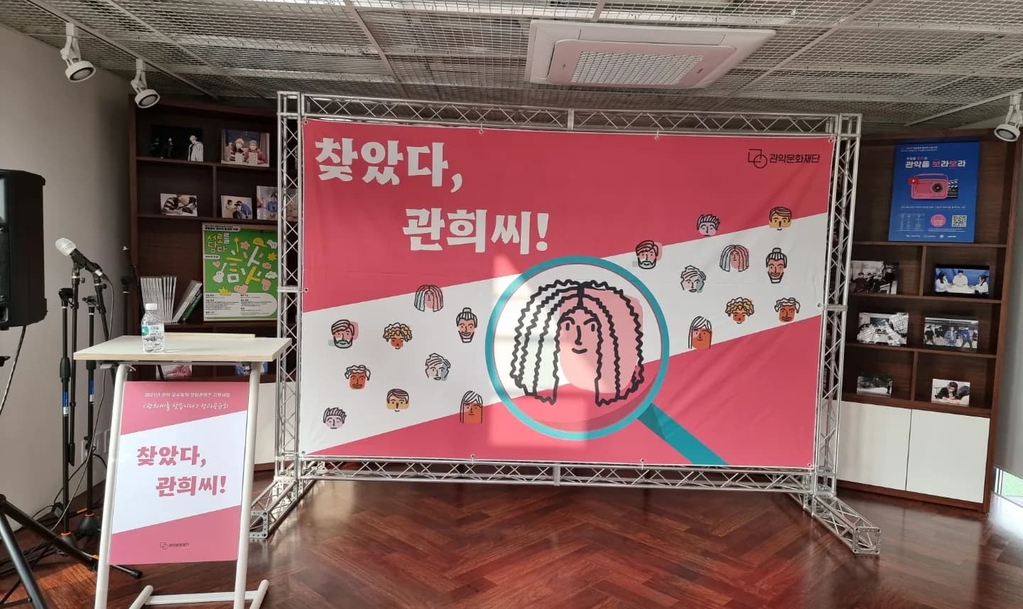 문화재단 라운지 책장 앞에 트러스로 세운 성과공유회 현수막 백월과 연단